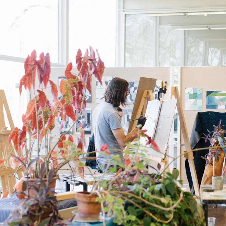 A person paints in an art studio