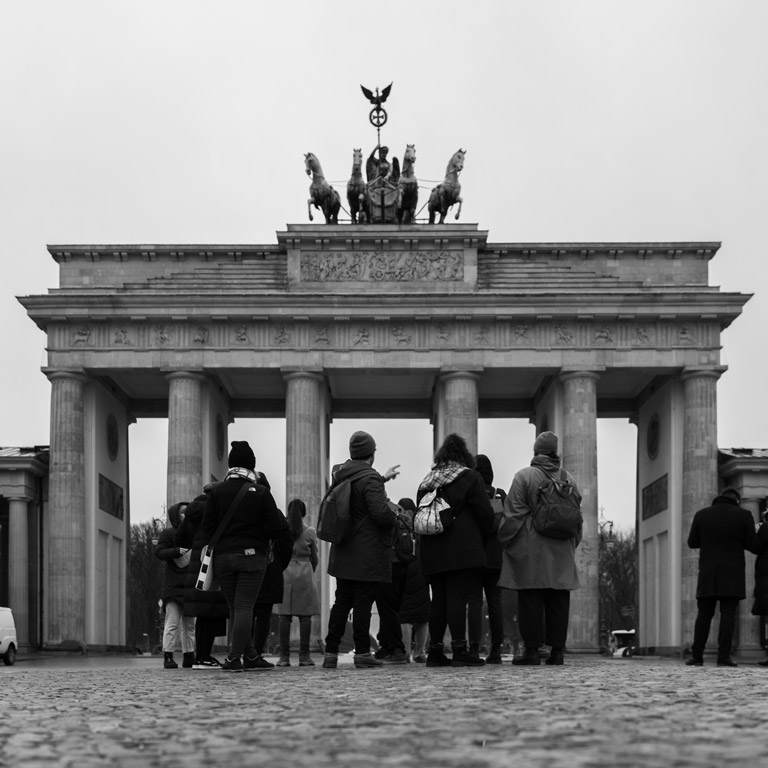 A black and white photo of students in front of a historic landmark in Berlin, Germany. 